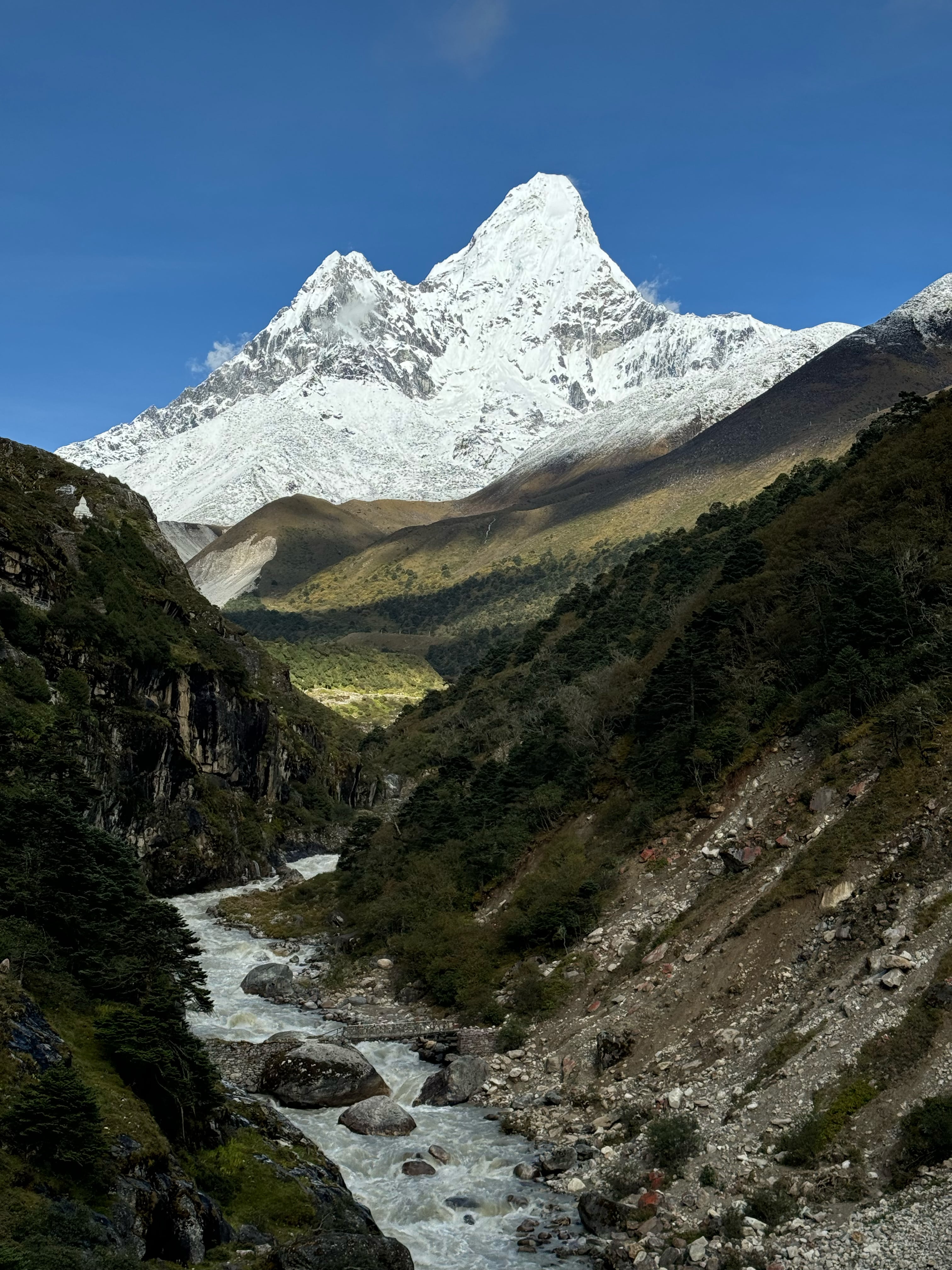 River flowing in front of Ama Dablam, with its majestic peak towering in the background, creating a picturesque and serene landscape in the Everest Region.