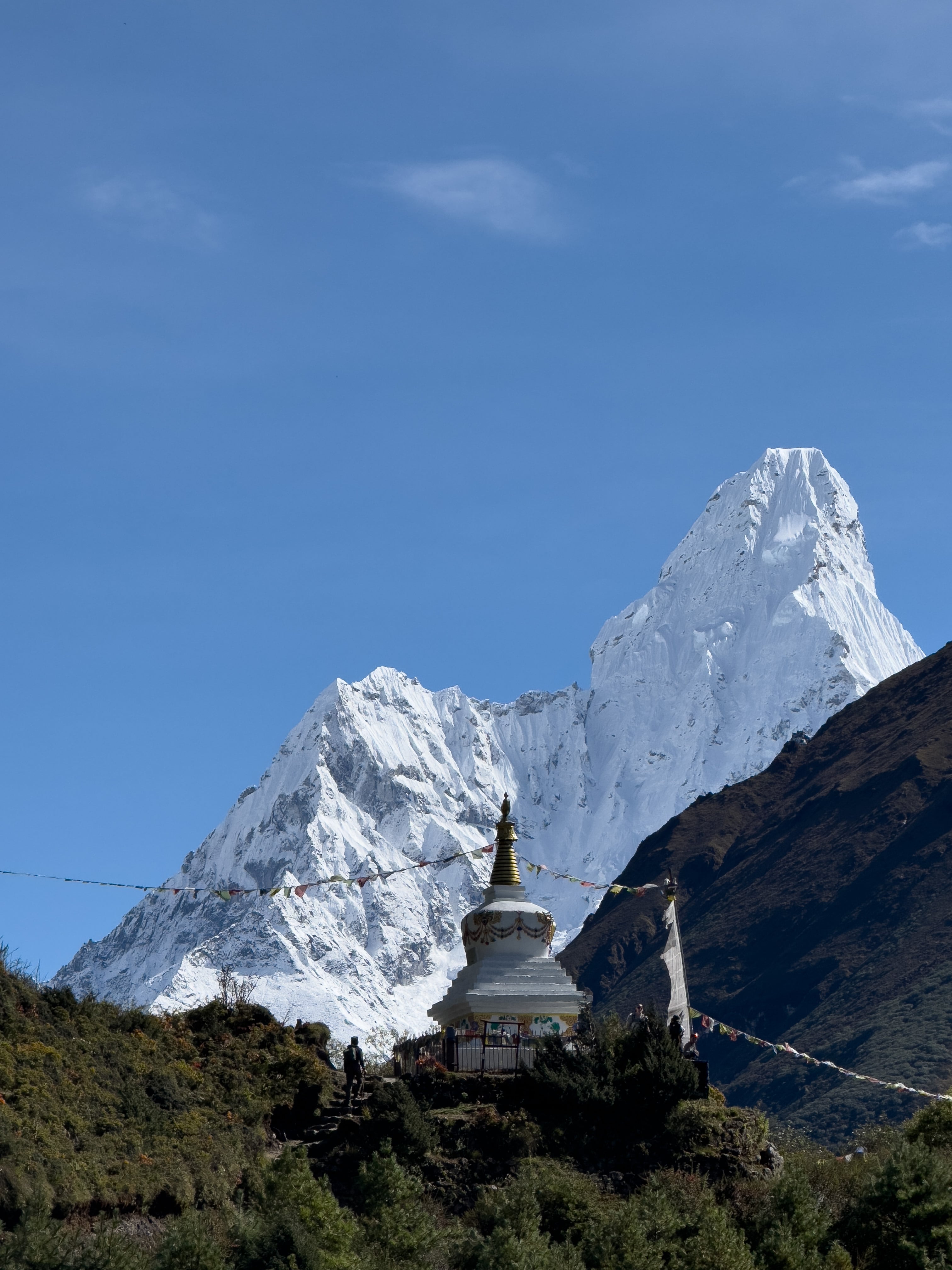 Stupa in front of Ama Dablam, with the iconic mountain towering majestically in the background, creating a peaceful and spiritual atmosphere in the Everest Region.