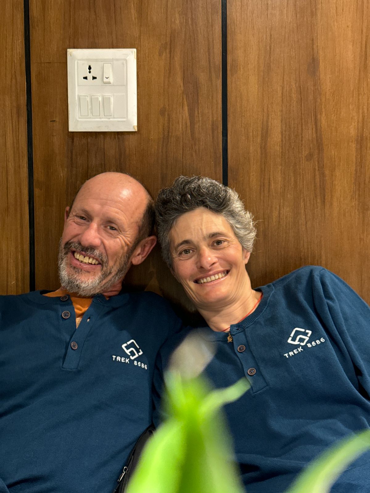 An elderly man and a woman wearing Trek 8586 sweaters enjoying the scenic Kanchenjunga Region, perfect for trekking adventures in Eastern Nepal with a trusted trekking agency.